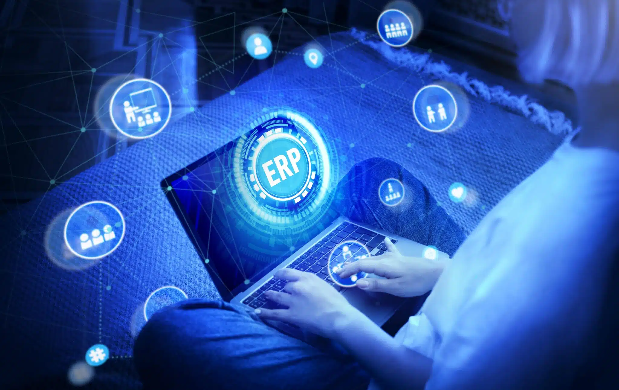 Laptop screen showing a holographic ERP dashboard with connected icons