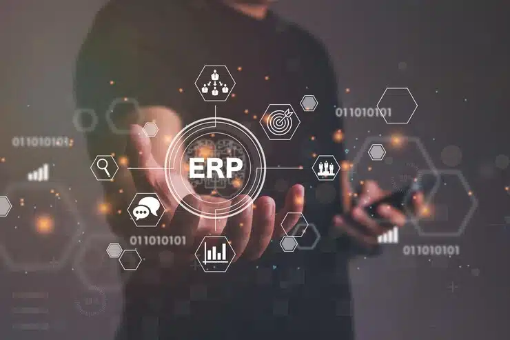 Businessman's hand touching a glowing ERP hologram connected to business icons